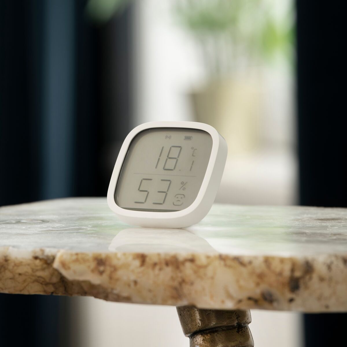 Sense MO - Zigbee Temperature Sensor - Ambiance Image of a Sense MO on a side table | Marmitek