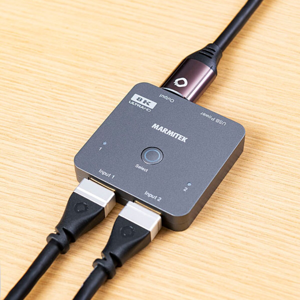 Connect 720 - HDMI switch 4K 120Hz, 8K 60Hz - 2 in / 1 out - Ambiance Image of Connect 720 on a table with 2 HDMI cables in and 1 HDMI cable out | Marmitek
